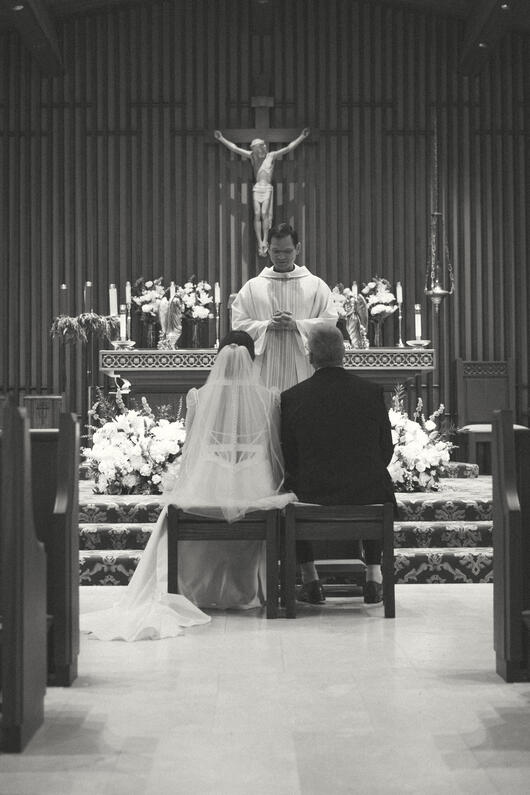 The couple says "I do" at the altar under Jesus and his love. The couple says "I do" at the altar under Jesus and his love.